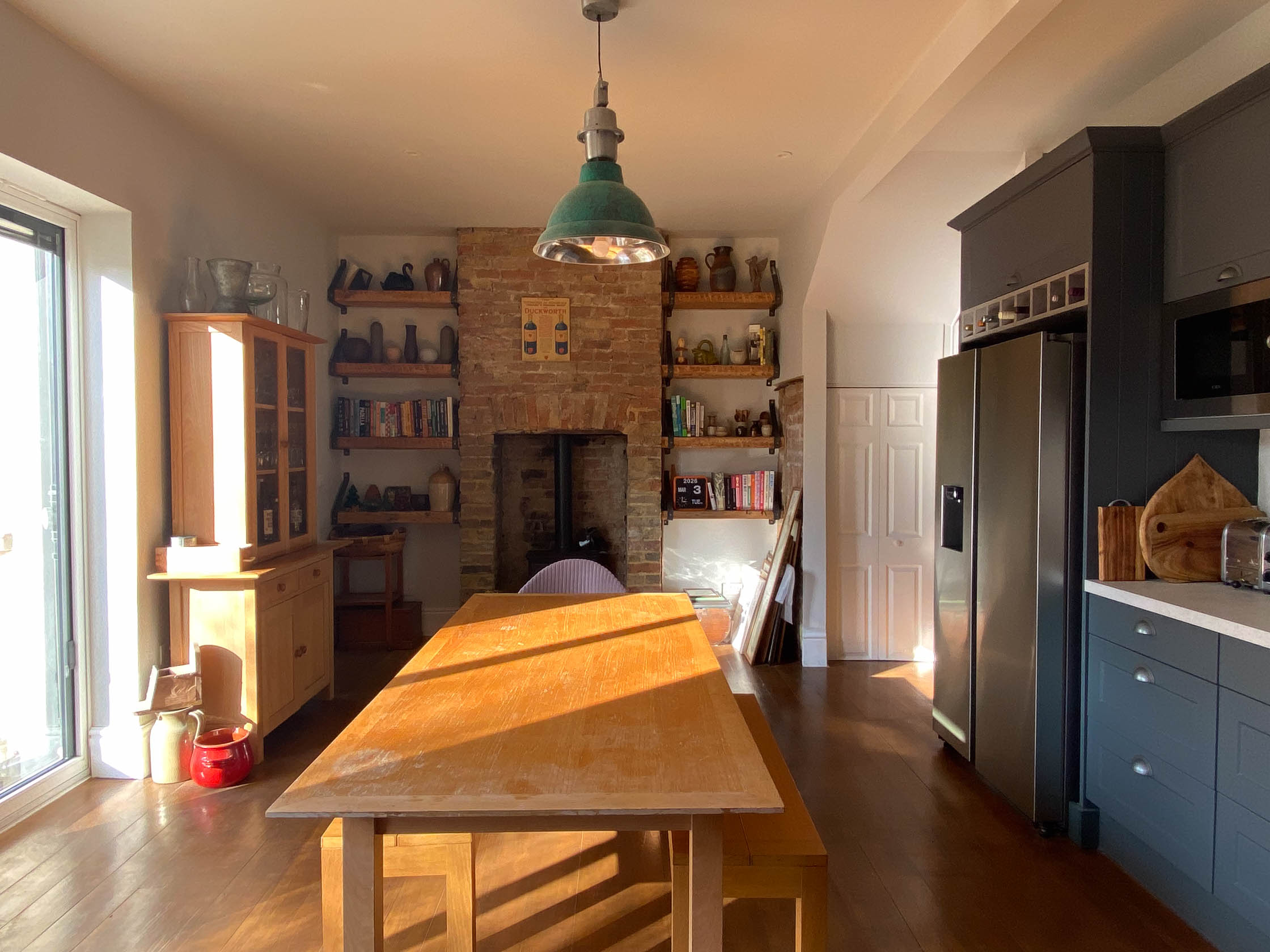 Kitchen dining area with exposed chimney stack wood burner